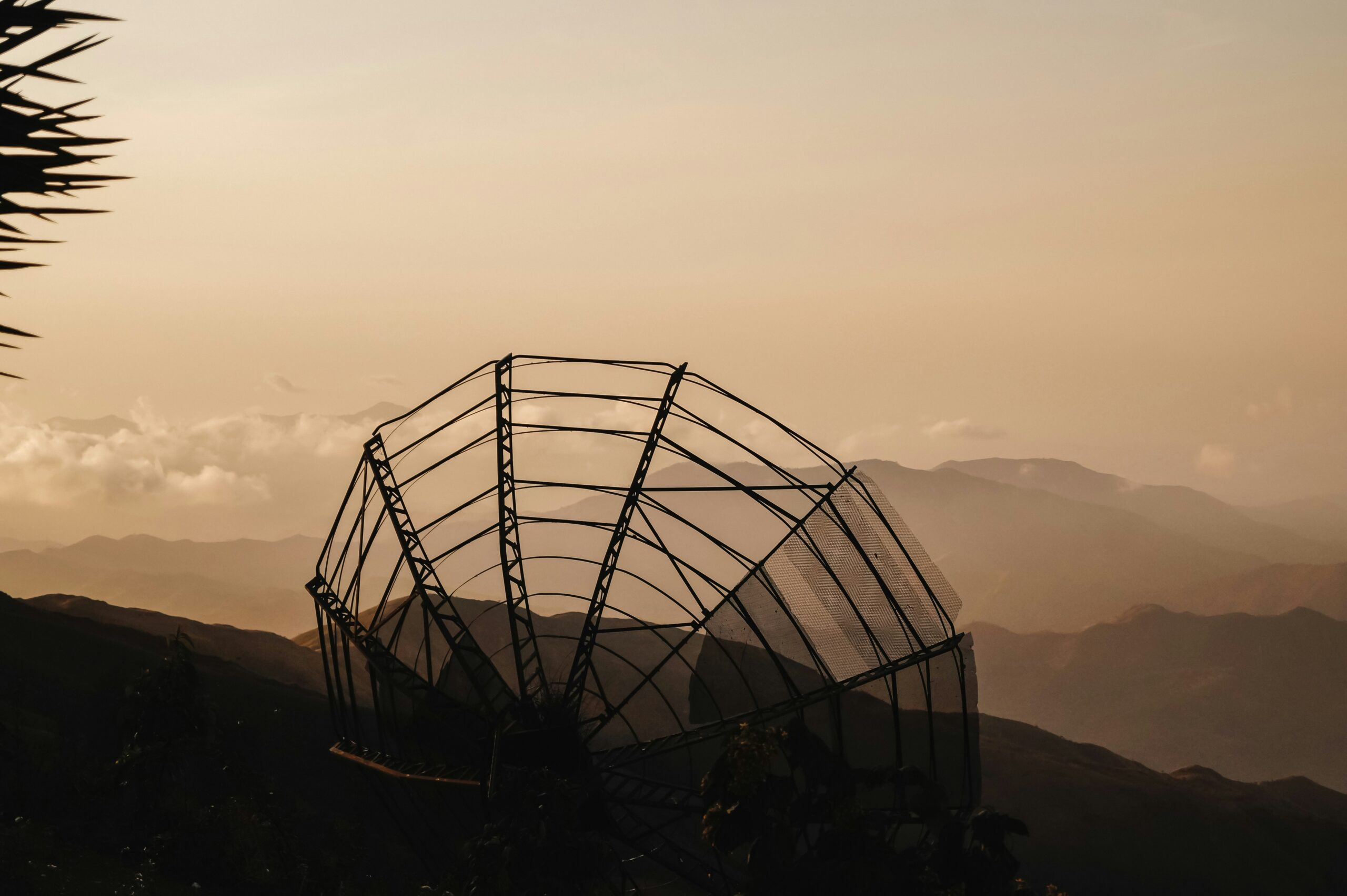 image of a radio dish in front of a mountain landscape
